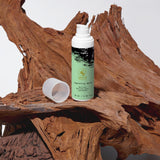 Bottle of Almay hair care product on a wooden surface