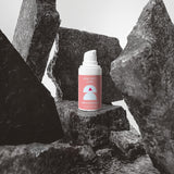 Pink spray can with a white nozzle on a black stone surface