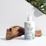 Bottle of sensitive skin face and body cleanser with natural elements on a white background